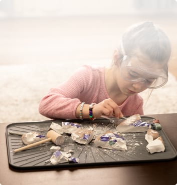 A child playing with a fossil kit.