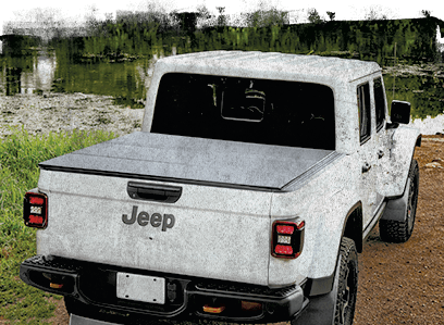Jeep parked on a muddy road with a WeatherTech Alloy Cover installed.