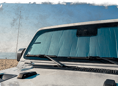 Jeep parked by a beach with a WeatherTech SunShade installed.