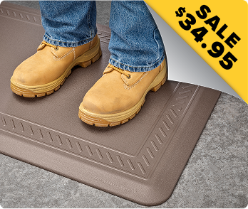 Man with boots on standing on a Comfort Mat.