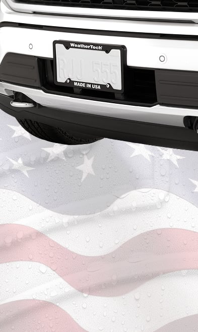 license plate frame on vehicle with american flag in background